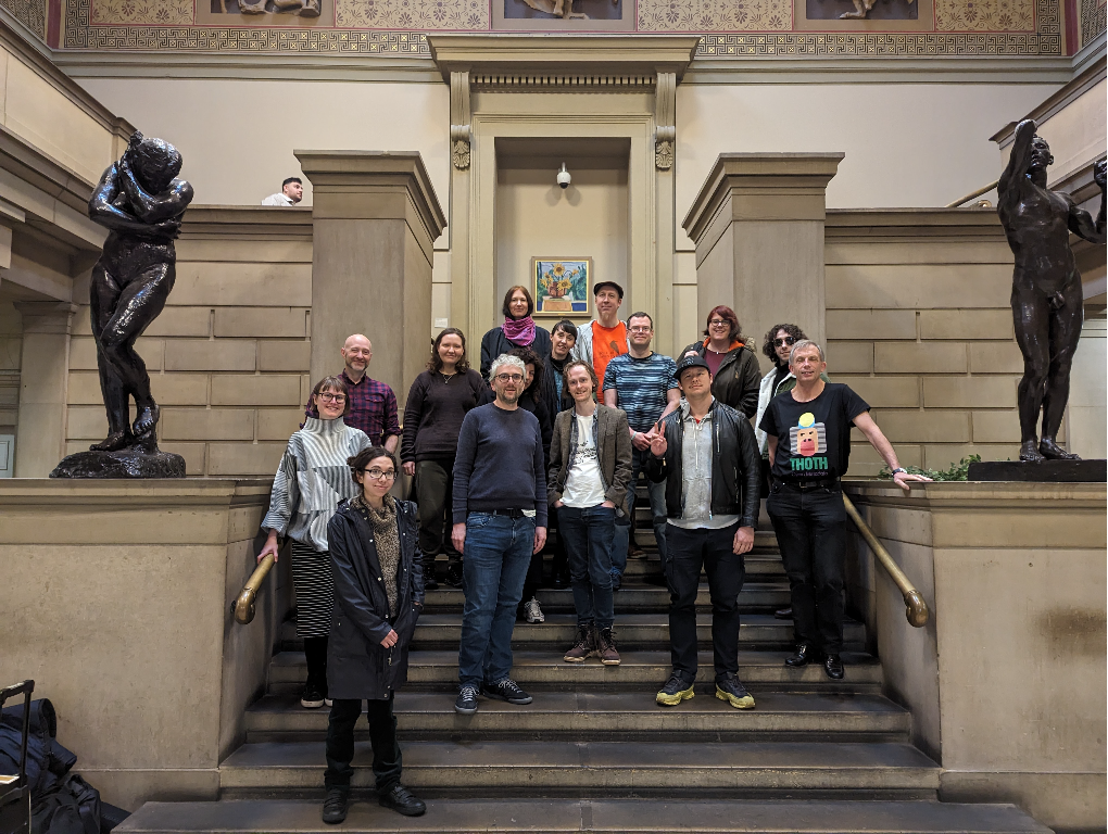 The Open Book Futures team on the stairs on the Manchester Museum